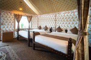 um quarto com duas camas num quarto em The Royal Heritage Tent Resort- Statue of Unity em Navgam