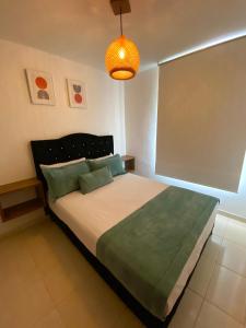 a bedroom with a large bed with a light at Apartamento con Piscina en Dosquebradas in Dosquebradas