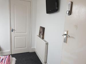 Habitación con puerta y TV en la pared en Townsend Studio/Rooms en Liverpool