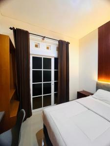 1 dormitorio con cama y ventana grande en House of Bedjo en Demangan