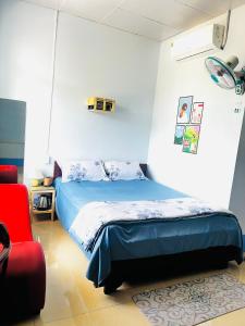 1 dormitorio con 1 cama y 1 silla roja en MOCA MOTEL en Cao Lãnh