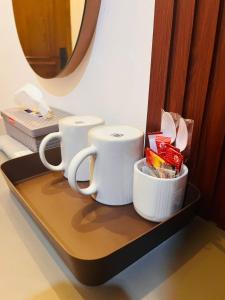House of Bedjo في Demangan: كوبين قهوة على رف في غرفة