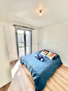 una camera da letto con letto con lenzuola e cuscini blu di Magnificent apart Paris Bagnolet 401 with view a Bagnolet