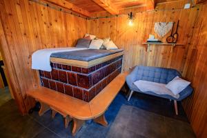 ein Bett und ein Stuhl in einem Holzzimmer in der Unterkunft Relax house AVUS with Sauna in Slap ob Idrijci