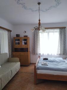 una camera con letto, divano e finestra di Ubytování Pod jilmem a Žár