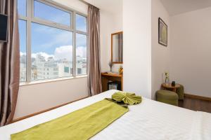 a bedroom with a bed and a large window at Richico Apartments And Hotel in Da Nang