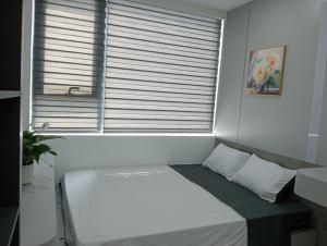 Bett in einem Zimmer mit Fenster in der Unterkunft Tom homestay, căn hộ Nera garden Huế in Hue