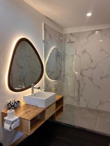 a bathroom with a sink and a mirror and a shower at Rock'n Reef in Uluwatu