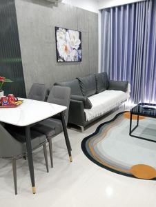 ein Wohnzimmer mit einem Sofa und einem Tisch in der Unterkunft Tom homestay, căn hộ Nera garden Huế in Hue