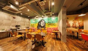 a restaurant with tables and chairs and a painting on the wall at Hotel Nomad - Vacation STAY 73941v in Hitachi
