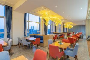 a restaurant with tables and chairs and windows at Holiday Inn Express Yinchuan Downtown, an IHG Hotel in Yinchuan