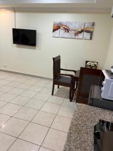een woonkamer met een televisie en een tafel bij FINE HOMES MIKOCHENI in Dar es Salaam