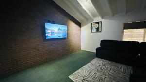 - un salon avec un canapé et un mur en briques dans l'établissement Varyam House, à Mildura