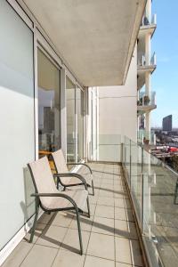 a balcony with two chairs on a building at 3 BR 2 Bath 2 Carparks next to Crown Casino in Melbourne