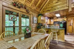 uma cozinha e sala de jantar com mesa e cadeiras em ER215 - Red Bird Haven cabin em Pigeon Forge mais 27 fotografias