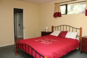 Un dormitorio con una cama con una manta roja. en 45 Alpine Avenue, en Hanmer Springs