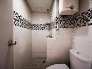 La petite salle de bains est pourvue d'une douche et de toilettes. dans l'établissement Raja Apartemen Jarrdin Type 33, à Bandung