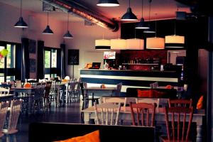 a restaurant with tables and chairs and a bar at Hotel Klondaik Corner in Warka
