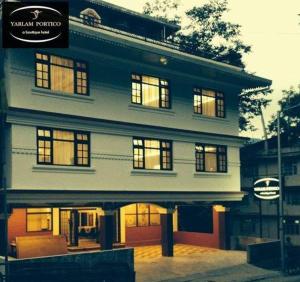 a large white building with lit up windows at Yarlam Portico in Gangtok