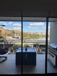 Una cocina con vista a un lago desde un balcón. en Lakeside 3 Bedroom home., en Melbourne