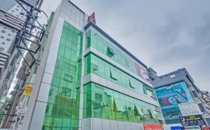 a building with glass windows in a city at Hotel O Sri Sai Guru Comforts in Bengaluru