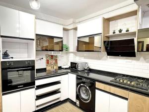 a kitchen with white cabinets and a washer at 3BR Nile View Zamalek island Abu El Feda Luxury in Cairo