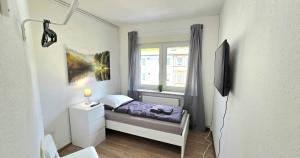 a small bedroom with a bed and a window at -CS24- 4 rooms apartment with rooftop - KA02 in Iserlohn