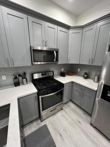 una cocina con electrodomésticos de acero inoxidable y armarios blancos en 1BR Hollywood Townhouse en Los Ángeles