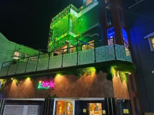 a building with a balcony with green and blue lights at Hotel Marine Blue in Digha