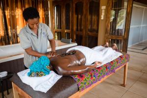 a woman laying on a bed while a woman is being examined at Sogakope Beach Resort & Spa in Sogakofe