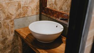 baño con lavabo blanco en una encimera de madera en Meliora bali villa, en Ubud