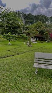 a park bench sitting in a field of grass at Sítio Por do Sol in Piçarras