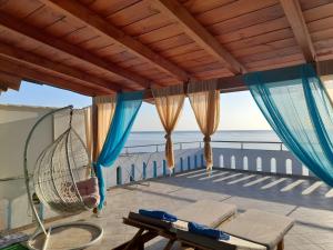 uma varanda com rede de descanso e vista para o oceano em Delfini em Akhladherí