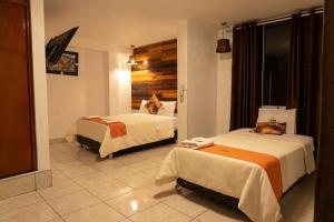 Una habitación de hotel con dos camas con gatos. en Ayacucho Plaza, en Ayacucho
