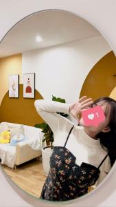 a woman holding a pink cup in a room at AmHome Premium Vinhome OceanPark in Hanoi