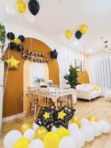 una habitación con una mesa con globos amarillos y negros en AmHome Premium Vinhome OceanPark en Hanoi