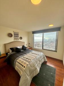 a bedroom with a large bed and a large window at Hermoso departamento en Iquique in Iquique