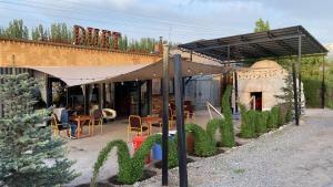 a restaurant with tables and chairs under a canopy at Duet Hostel & Hotel in Karakol