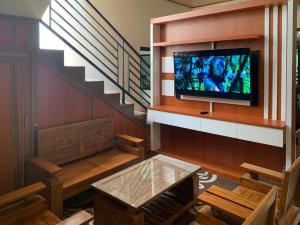 KejajarにあるSenja Dieng Homestay Syariah RedPartnerのリビングルーム(テレビ付)、階段