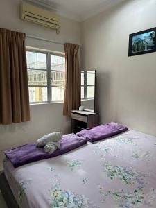 1 cama grande en un dormitorio con ventana en Greenleaf Angsana Homestay, en Jerantut