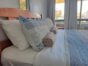 a bed with pillows and towels on it at Whatuwhiwhi TOP 10 Holiday Park in Tokerau Beach