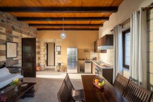 Blue Pearl Villa في AmigdhalokeFálion: مطبخ بسقف خشبي وطاولة طعام