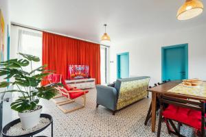 sala de estar con mesa, sillas y cortina roja en Villa Capri-Kaprovani, en Shekhvetili