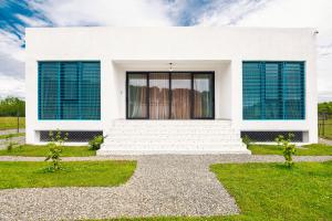 Biały dom z niebieskimi okiennicami w obiekcie Villa Capri-Kaprovani w mieście Shekhvetili