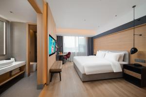 a hotel room with a bed and a bathroom at Park Inn by Radisson Chengdu Wuhou Shrine in Chengdu