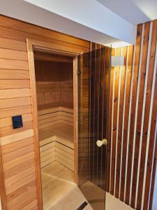 una sauna con paredes de madera y una puerta de cristal en Apartmán PANORÁMA en Liptovský Mikuláš