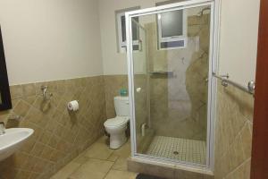 a bathroom with a toilet and a glass shower at Sunset View 10 @ Langstrand in Langstrand