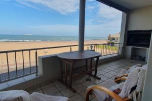 a balcony with a table and a view of the beach at Sunset View 10 @ Langstrand in Langstrand