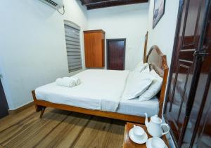 a small bedroom with a bed and a table at Pop Tavern Private Pool Villa Kovalam by VOYE HOMES in Kovalam