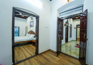 a room with a bed and a mirror at Pop Tavern Private Pool Villa Kovalam by VOYE HOMES in Kovalam